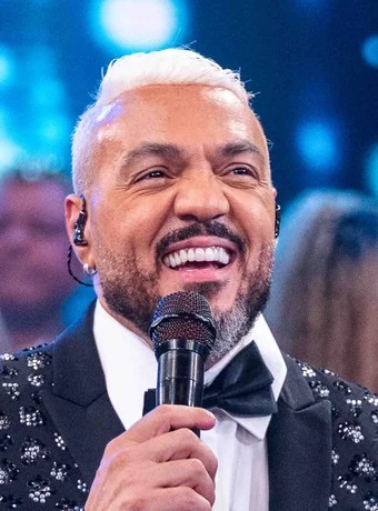 Belo no Altas Horas, com cabelo platinado penteado e maior volume aparente.