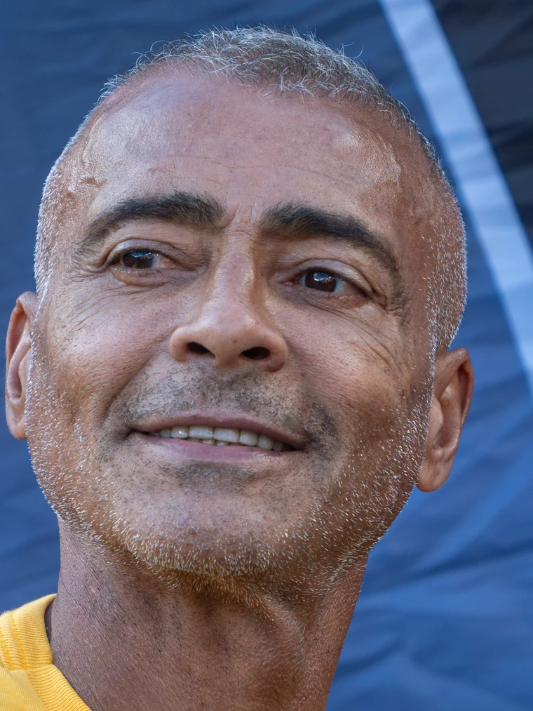 Romário na Copa de 2026, com fios grisalhos na linha frontal e rarefação ainda visível.