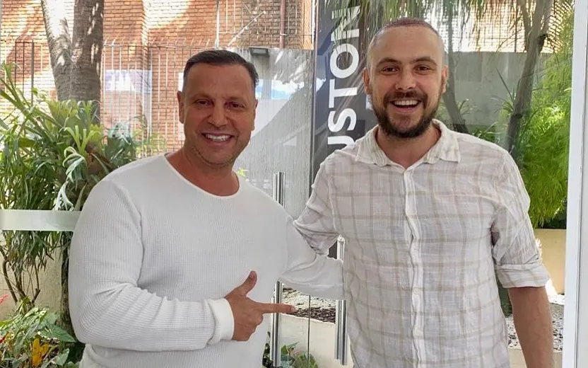 Sergio Guizé com cabelo raspado e região frontal visível, ao lado do médico Antonio Ruston na clínica.