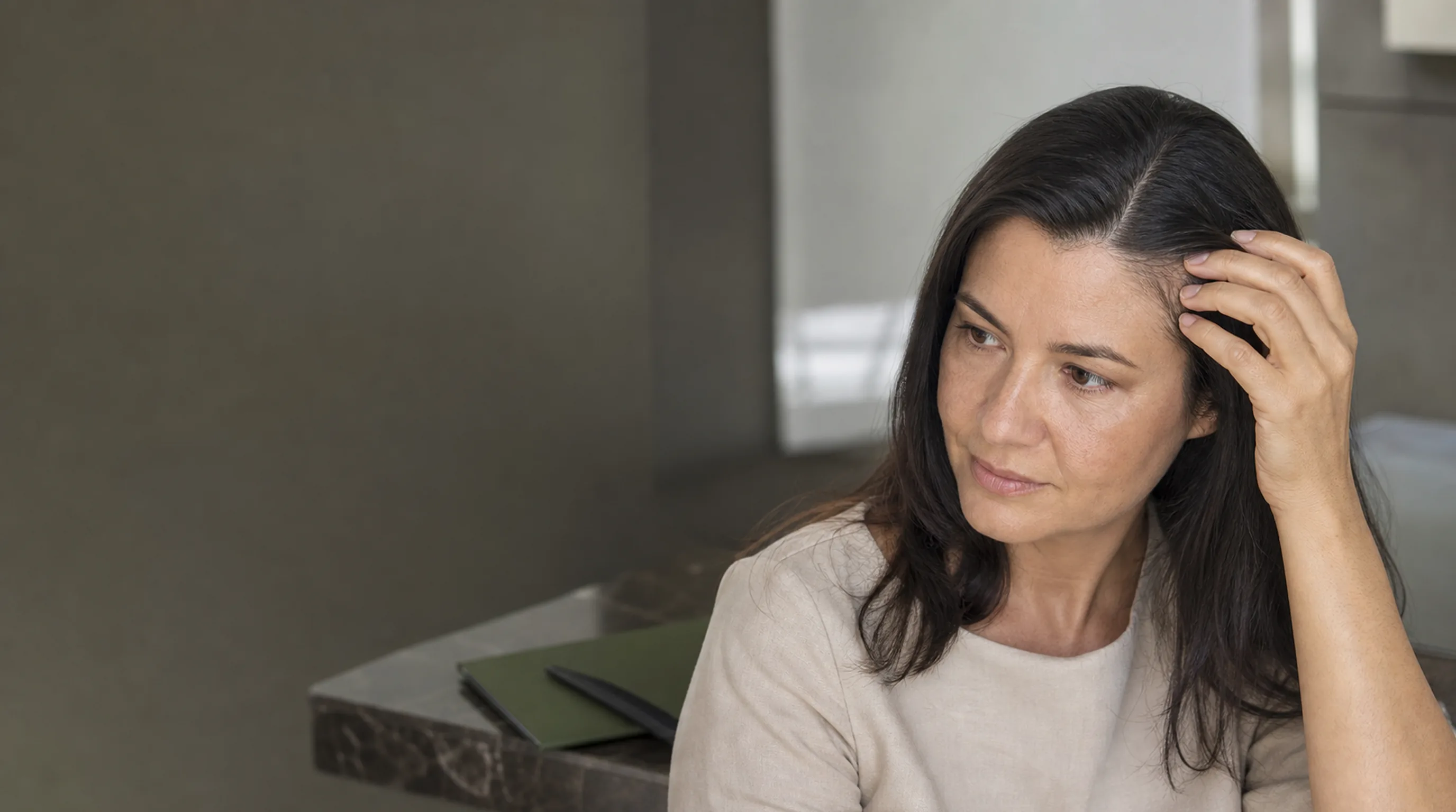 Mulher adulta observa a divisão do cabelo durante avaliação de tratamento capilar