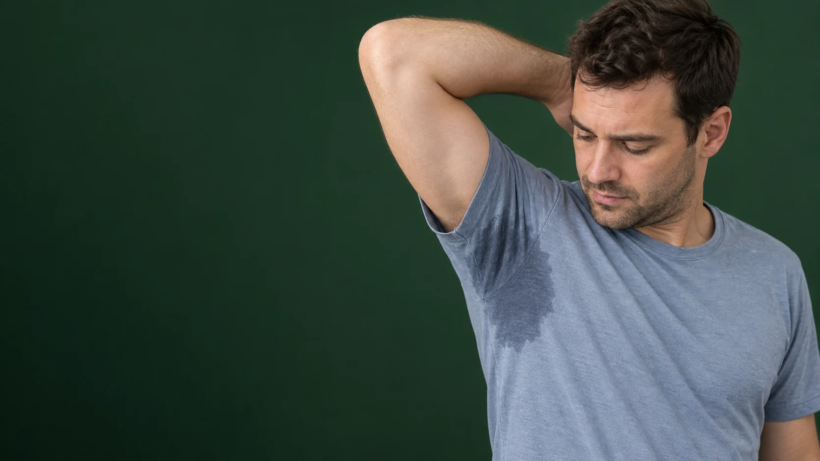 Cena ilustrativa de homem observando uma mancha de suor na axila da camiseta, na página sobre tratamento da hiperidrose